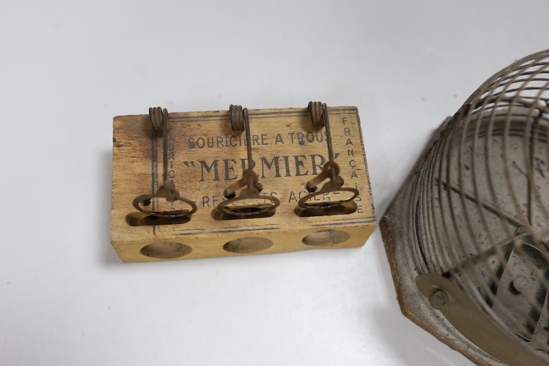 A circular metal mouse trap and a Mermier mouse trap